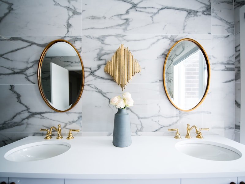 Luxe brass fixtures on marble — high-end faucet, vanity, and trim installation.